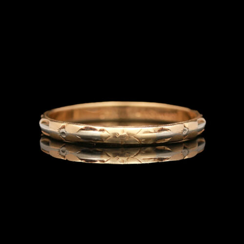 a gold wedding band with an intricate design