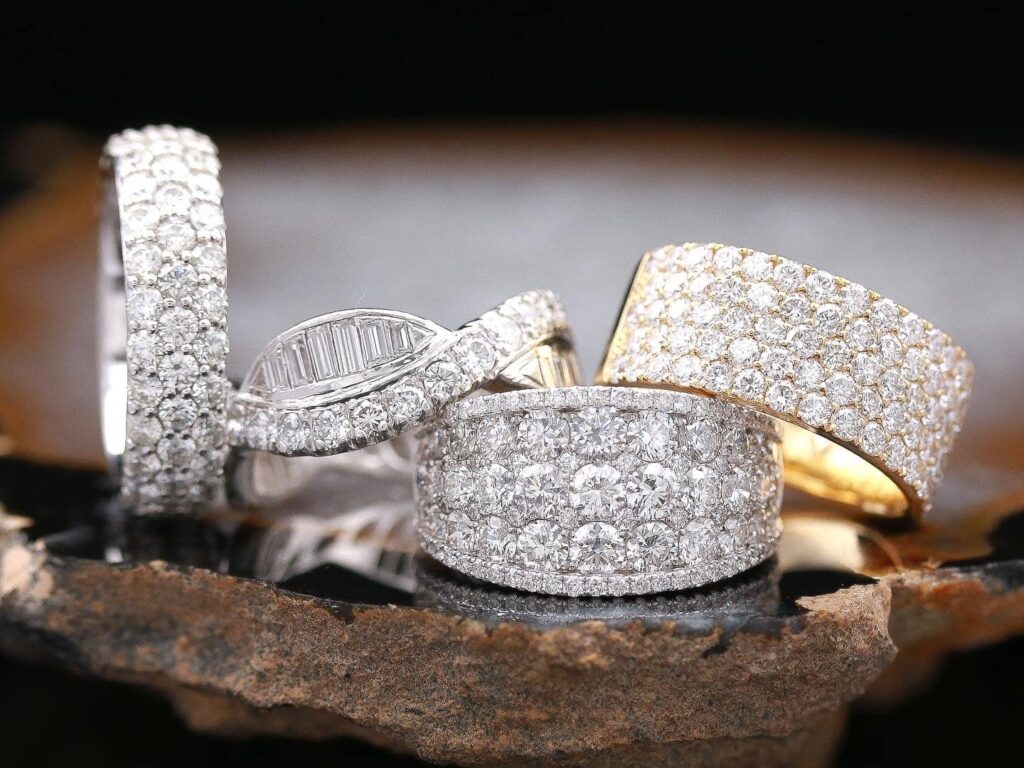A collection of four bold statement rings covered in diamonds.
