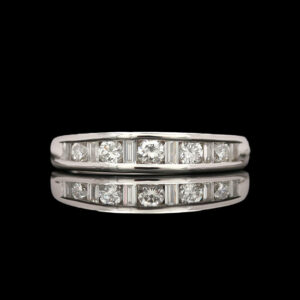 a diamond set wedding ring on a black background