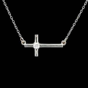 a silver cross necklace with a diamond on it