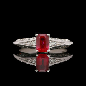 a close up of a ring with a red stone