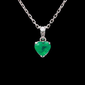 a necklace with a heart shaped green stone
