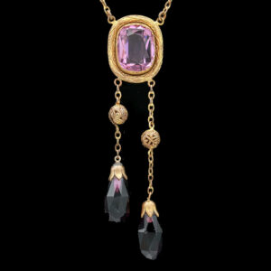 a necklace with a pink stone and two gold chains