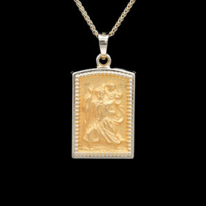 a gold pendant with an image of jesus on it